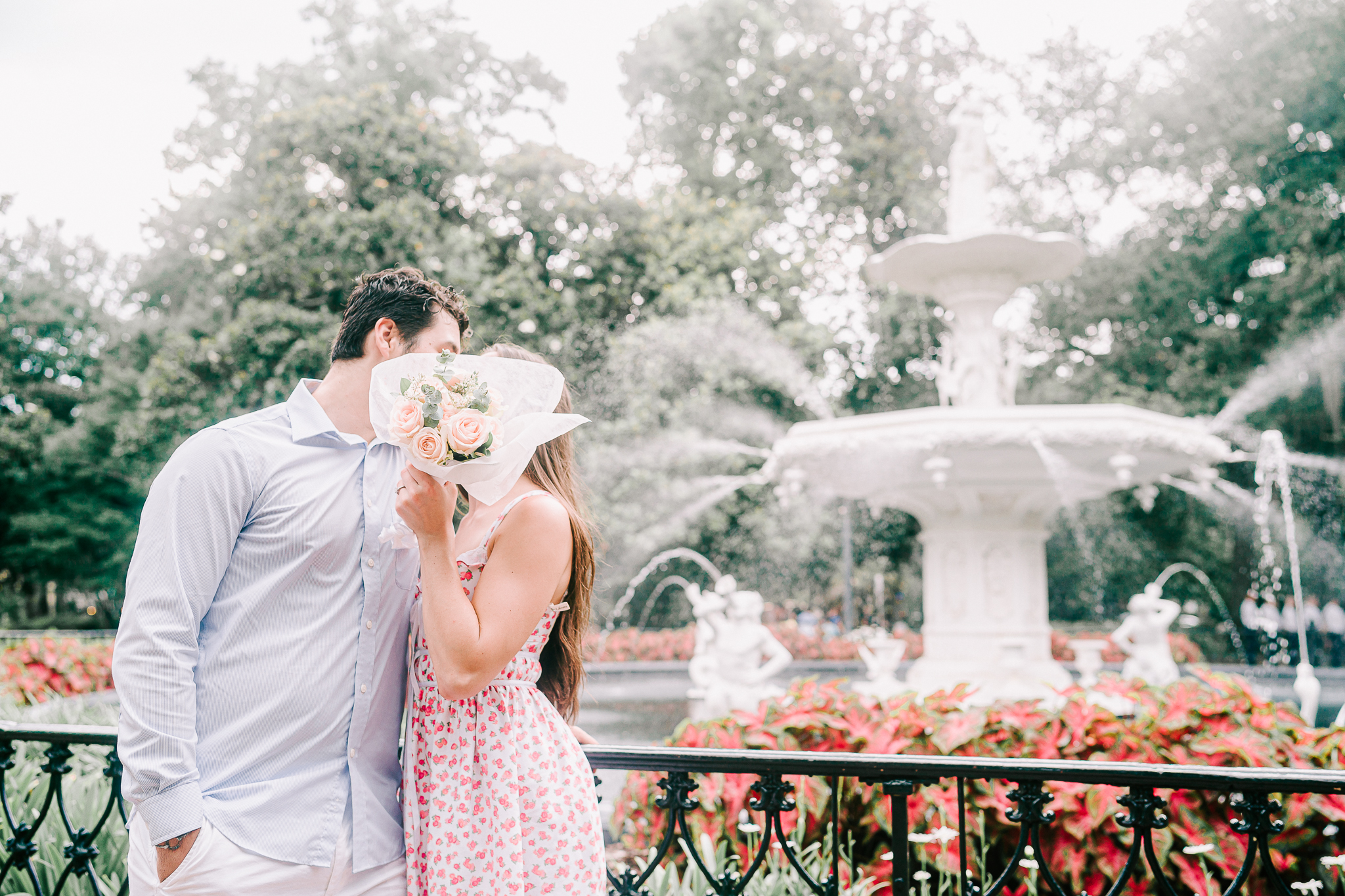 Couple posing with flowers at the fountain in Forsyth Park in Savannah, GA.